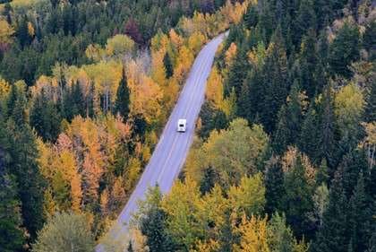 Fall Destinations In Northeast US rv driving on road in forest