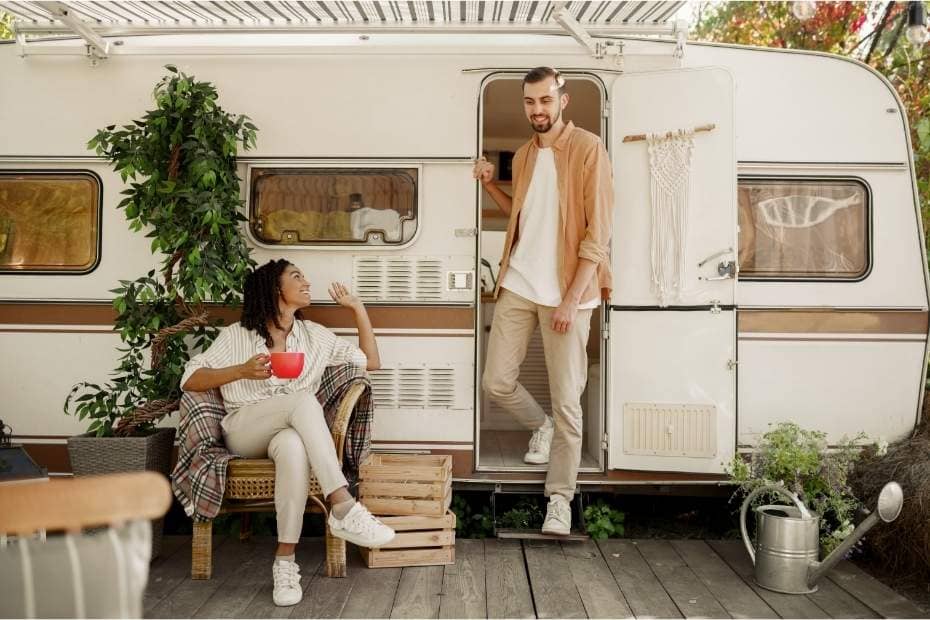 happy couple in front of rv travel trailer camper